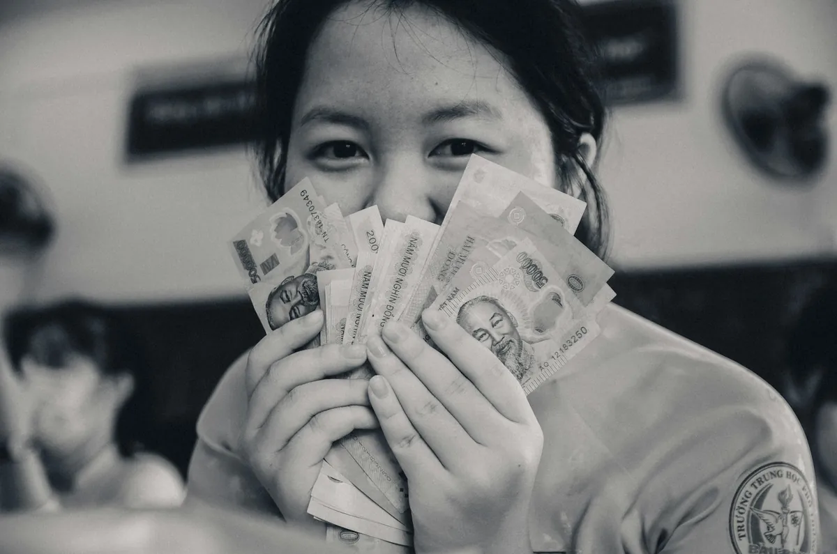 손에 쥔 지폐 다발 — 한 번에 받지 않고 매월 나눠 받는 연금복권의 특징